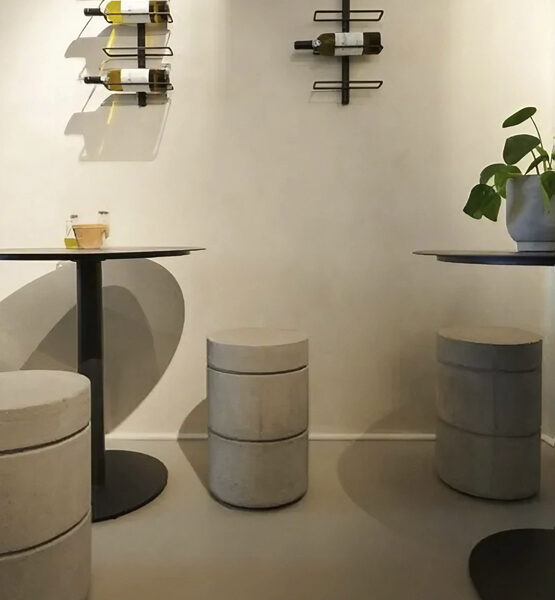 bar minimalista color cafe con mesas redondas y taburetes